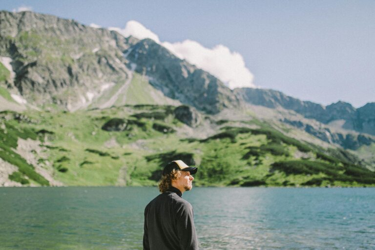 A Man Wearing a Cap while Standing Near the Body of Water