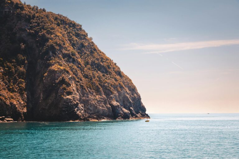 Brown and Green Mountain Beside Body of Water